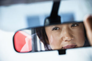 Woman Looking in Rearview Mirror